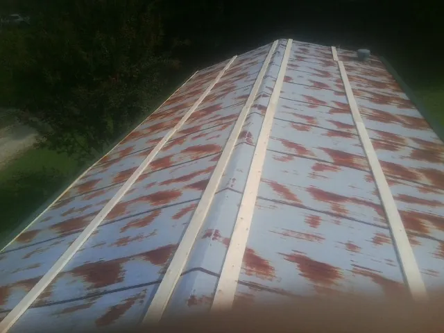 Rusted metal roof panels with new wood purlins before replacement — Storm Damage Roof Repair in Platteville by Roofing Brothers